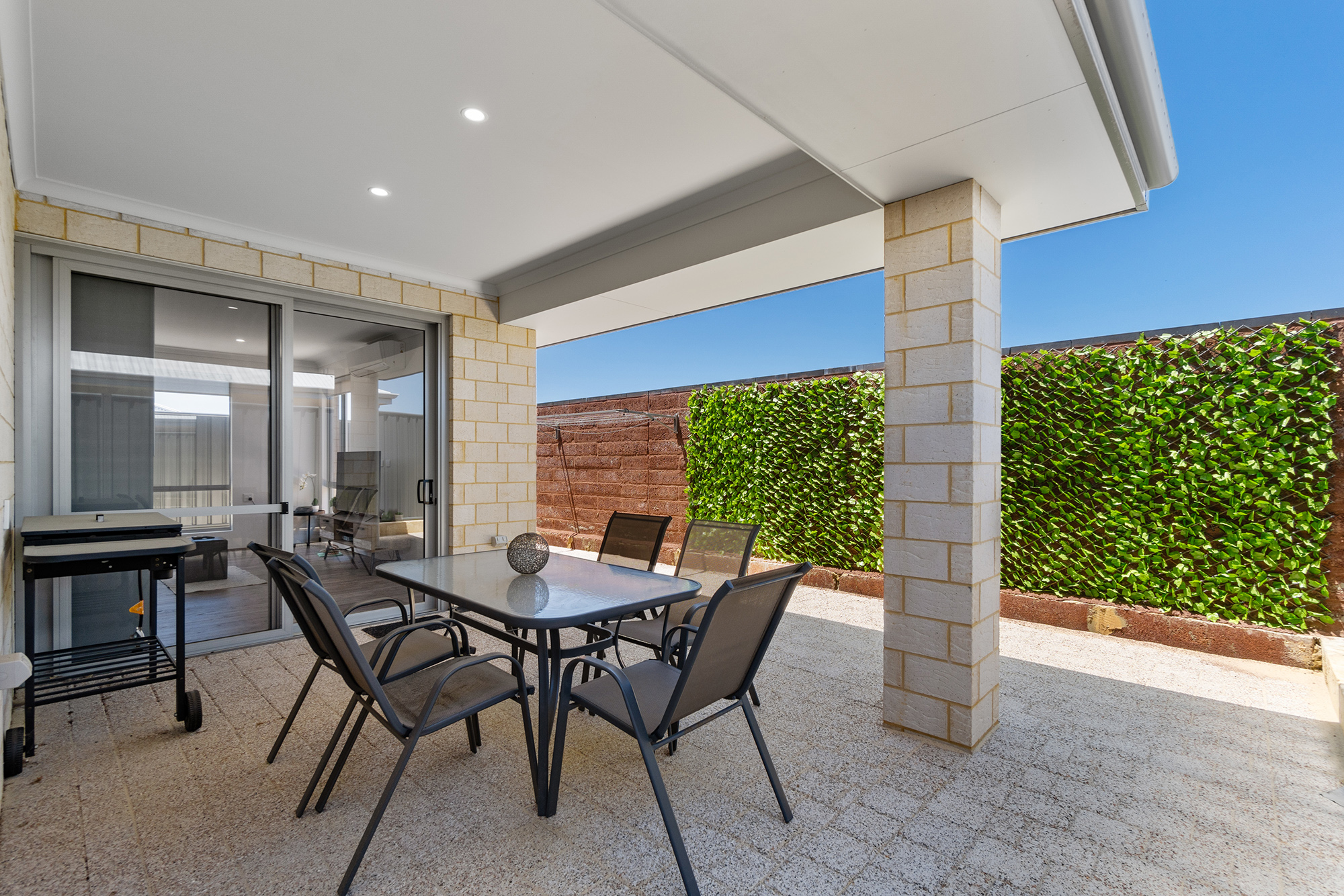 Accessible outdoor dining area undercover with dining table and chairs in private garden space