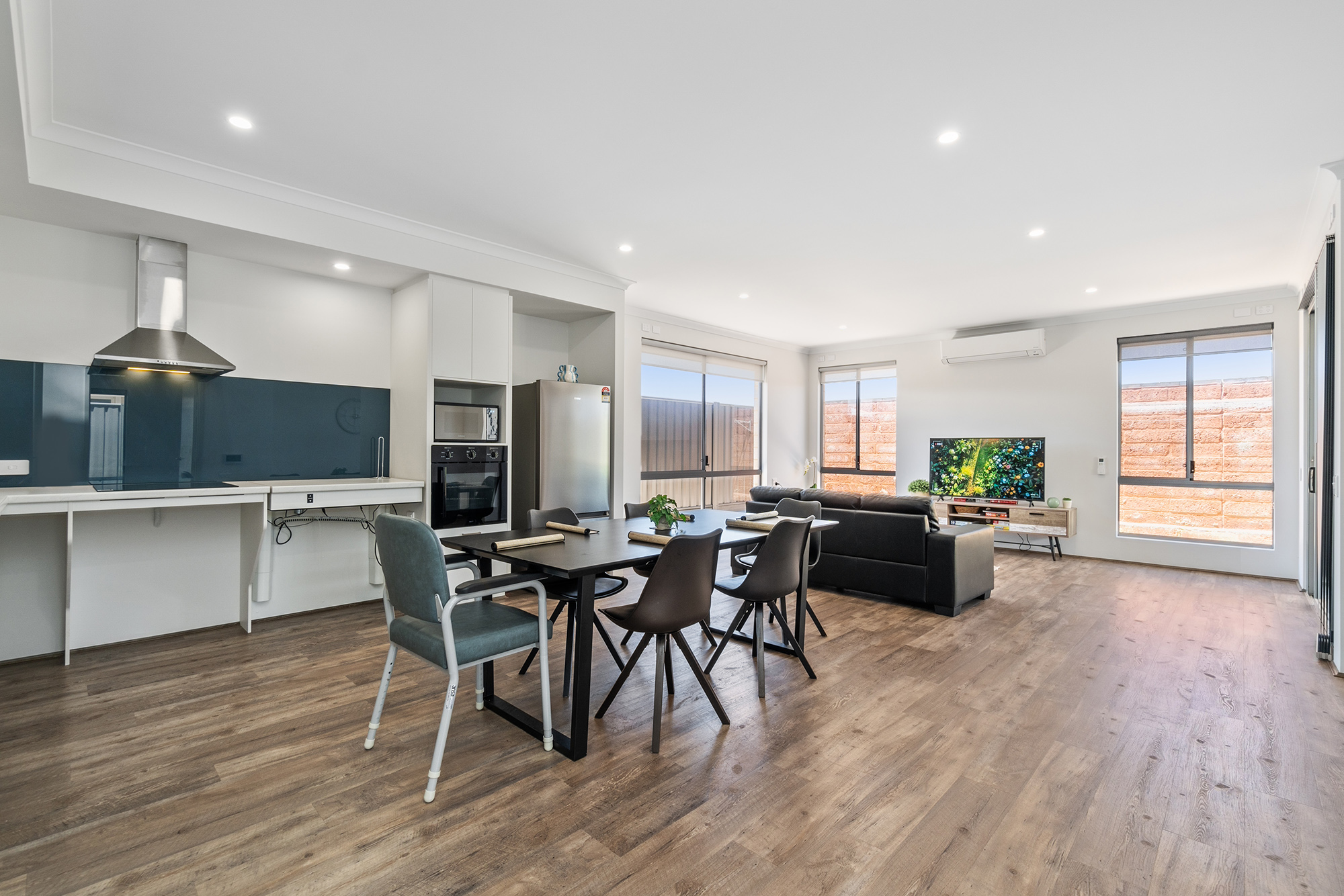 Light kitchen, dining and living space flow together. Furnished for watching tv or sharing a meal.